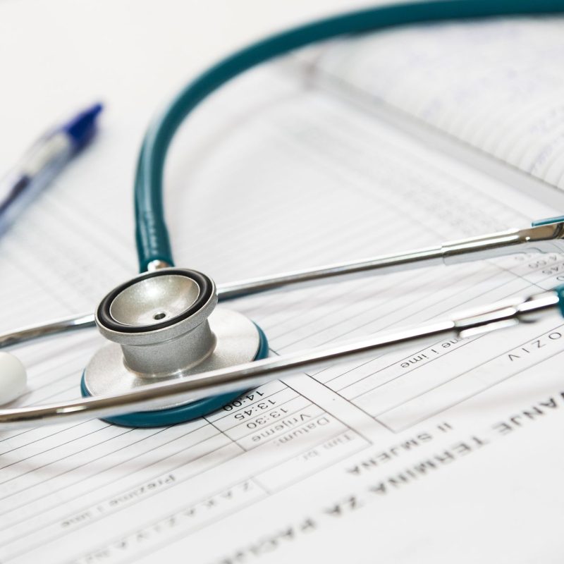 A stethoscope and pen resting on a medical report in a healthcare setting. — Don't Give Up on Hair Decline Remedy plans But -