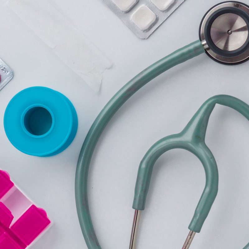 Overhead shot of medical supplies including stethoscope, pills, and scissors. — Famend Costs on Personal Adversity