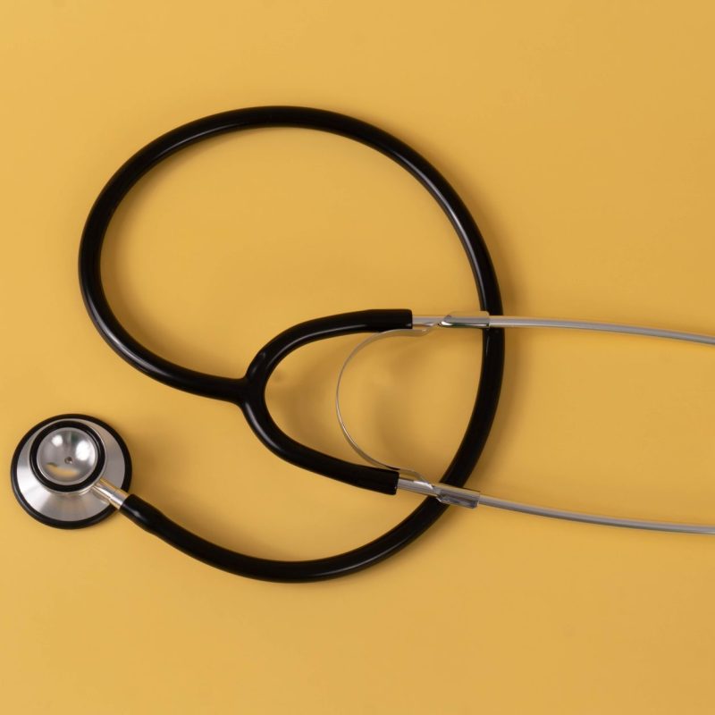 Close-up of a black stethoscope on a vibrant yellow surface, ideal for medical themes. — Female Hair Decline: What Sepia Can