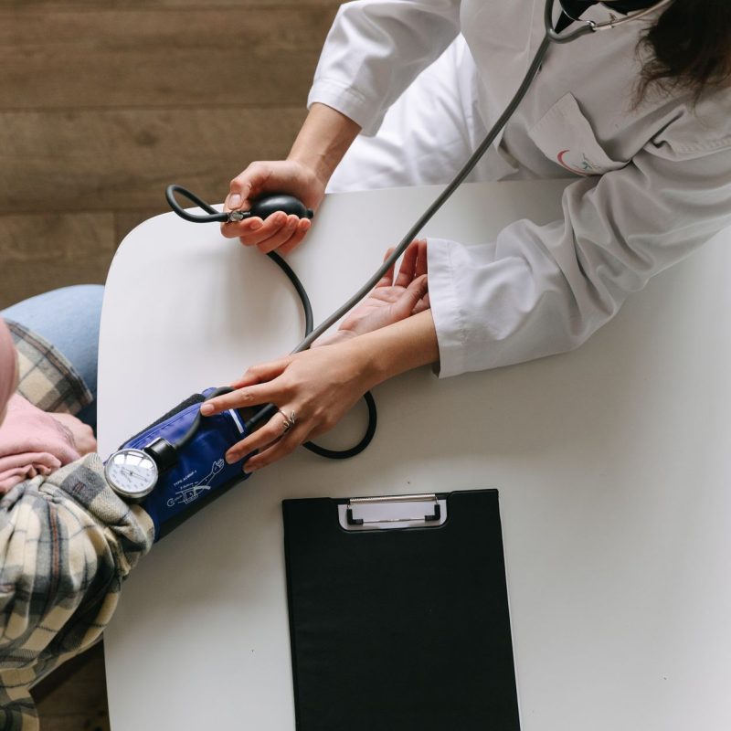 A medical practitioner checks a patient's blood pressure in a clinical setting, showcasing healthcare service. — Female Sampl