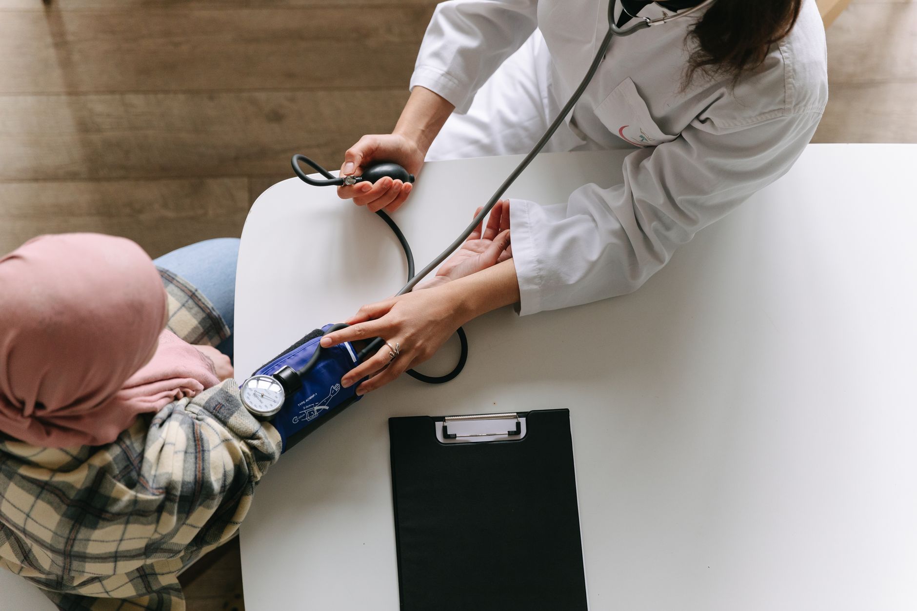 A medical practitioner checks a patient's blood pressure in a clinical setting, showcasing healthcare service. — Female Sampl