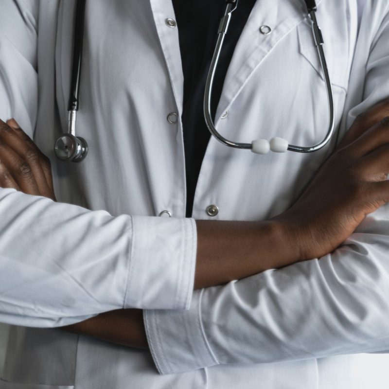Close-up of a confident doctor in a lab coat standing with crossed arms and stethoscope. — Hair Discount Strategies for the Y