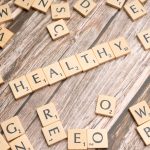 Wooden letter tiles arranged on a wooden surface spelling out 'healthy', symbolizing wellness. — Largest Distinction Regardin