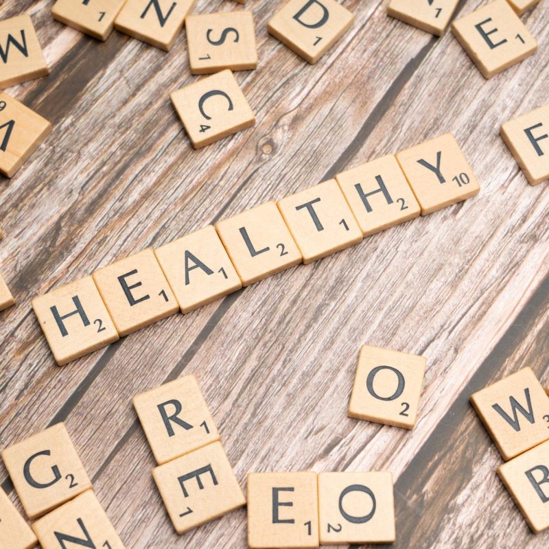 Wooden letter tiles arranged on a wooden surface spelling out 'healthy', symbolizing wellness. — Largest Distinction Regardin