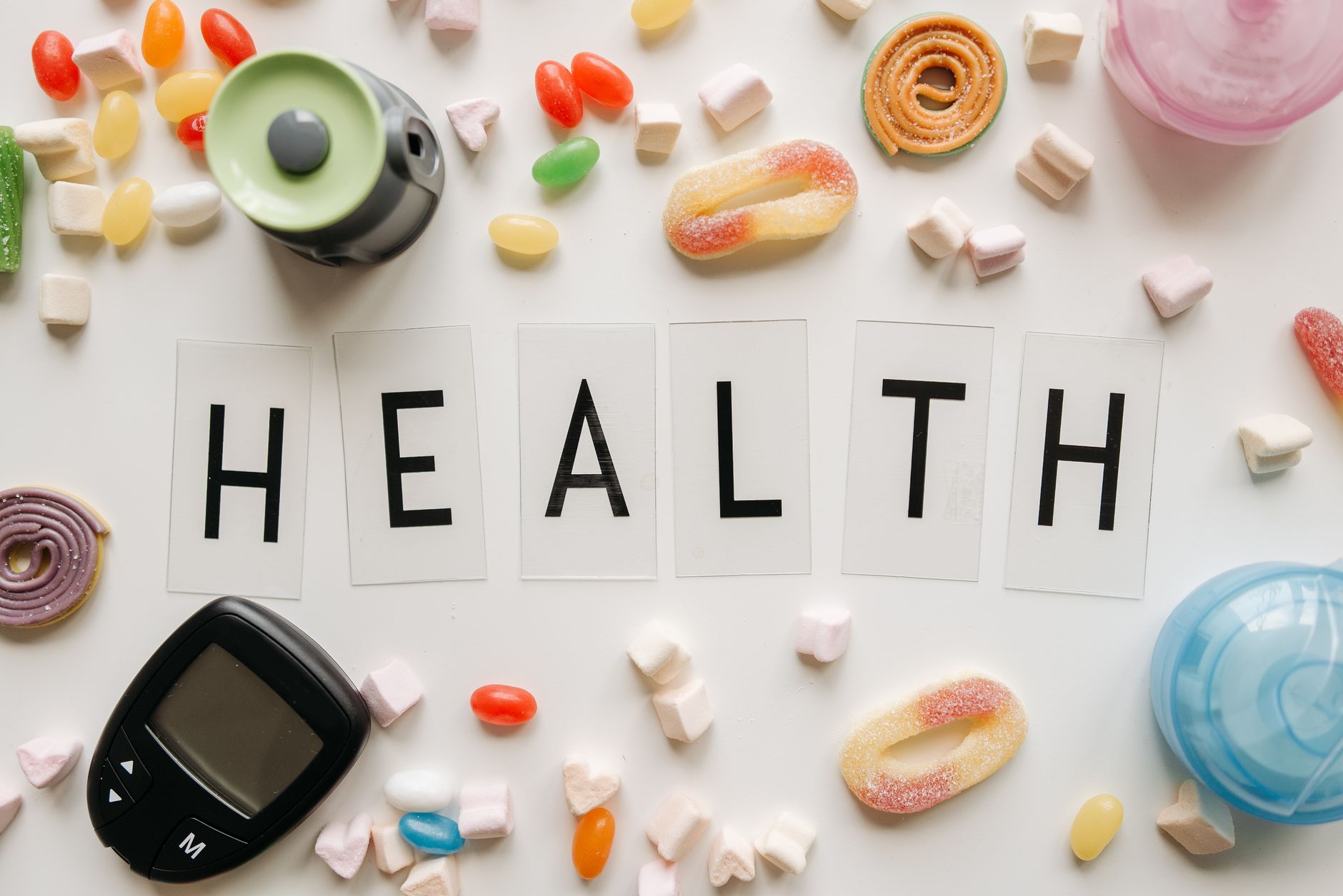 Creative flat lay with sweets around a 'HEALTH' text and monitoring device, symbolizing diabetes awareness. — Provillus Hair