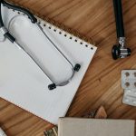 Flat lay of medical tools and supplies on a wooden desk surface. — The Beautiful Actuality About Feminine Hair Decline