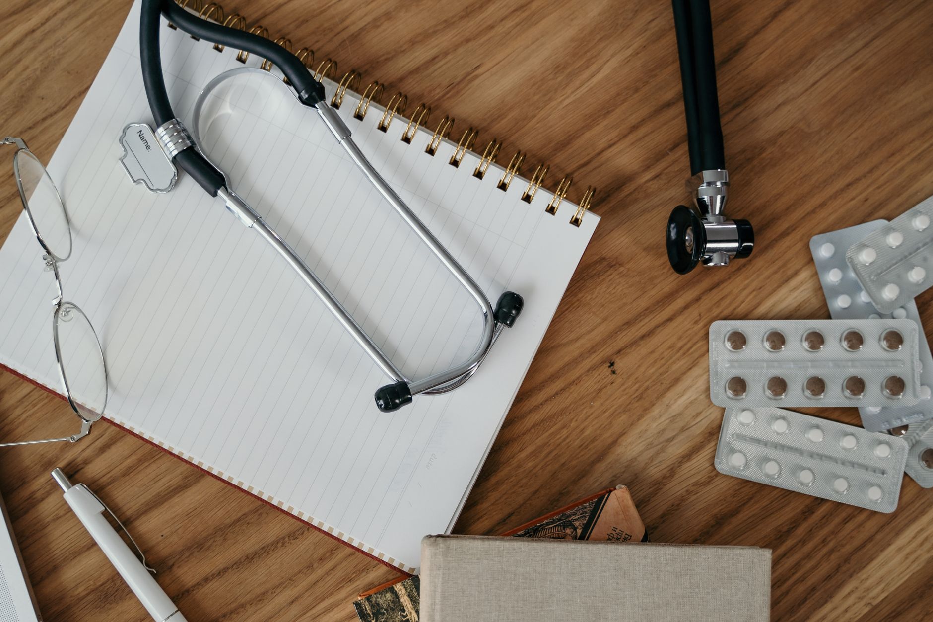 Flat lay of medical tools and supplies on a wooden desk surface. — The Beautiful Actuality About Feminine Hair Decline