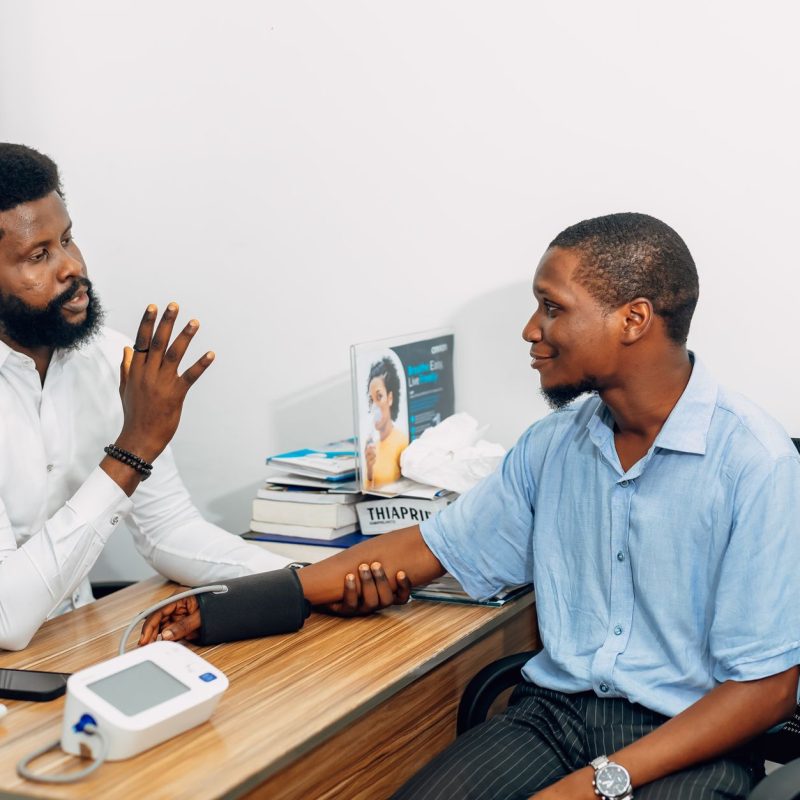 A medical professional consults with a patient during a blood pressure checkup in Lagos, Nigeria. — The Symbolism and Which s