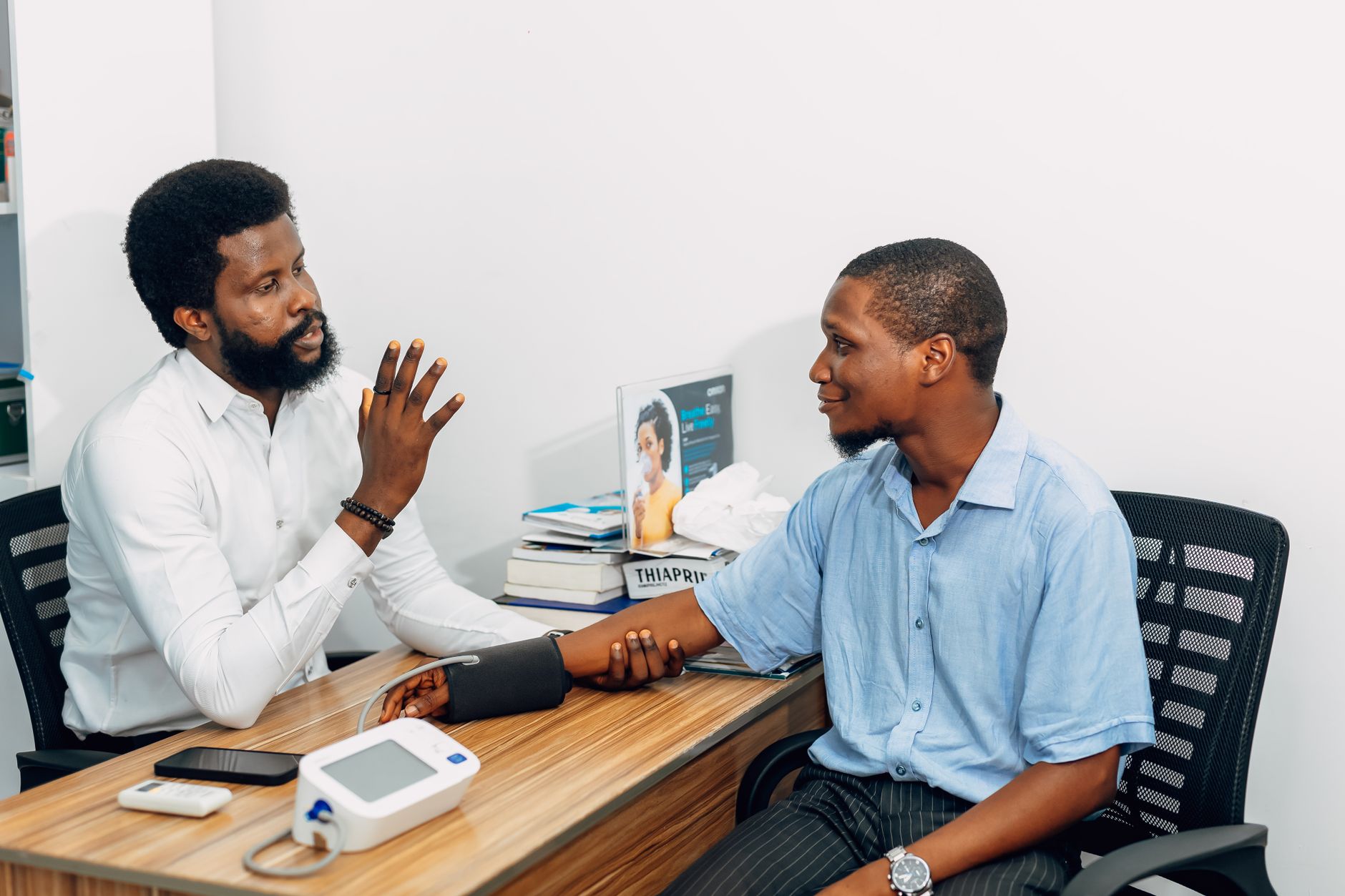 A medical professional consults with a patient during a blood pressure checkup in Lagos, Nigeria. — The Symbolism and Which s