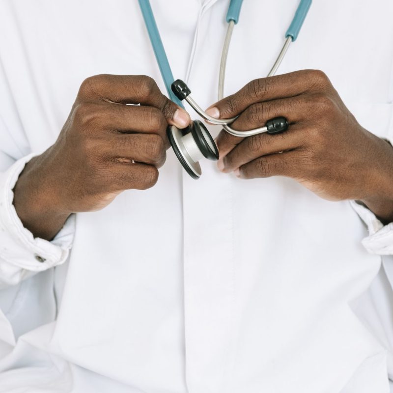 A professional doctor holding a stethoscope, focusing on hands and medical tools. — What To Select Involving A Hair Transplan