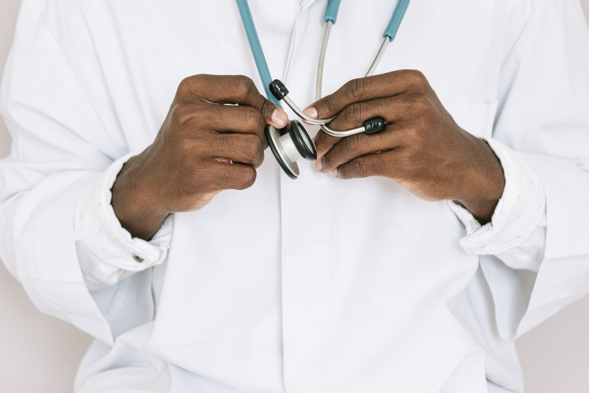 A professional doctor holding a stethoscope, focusing on hands and medical tools. — What To Select Involving A Hair Transplan