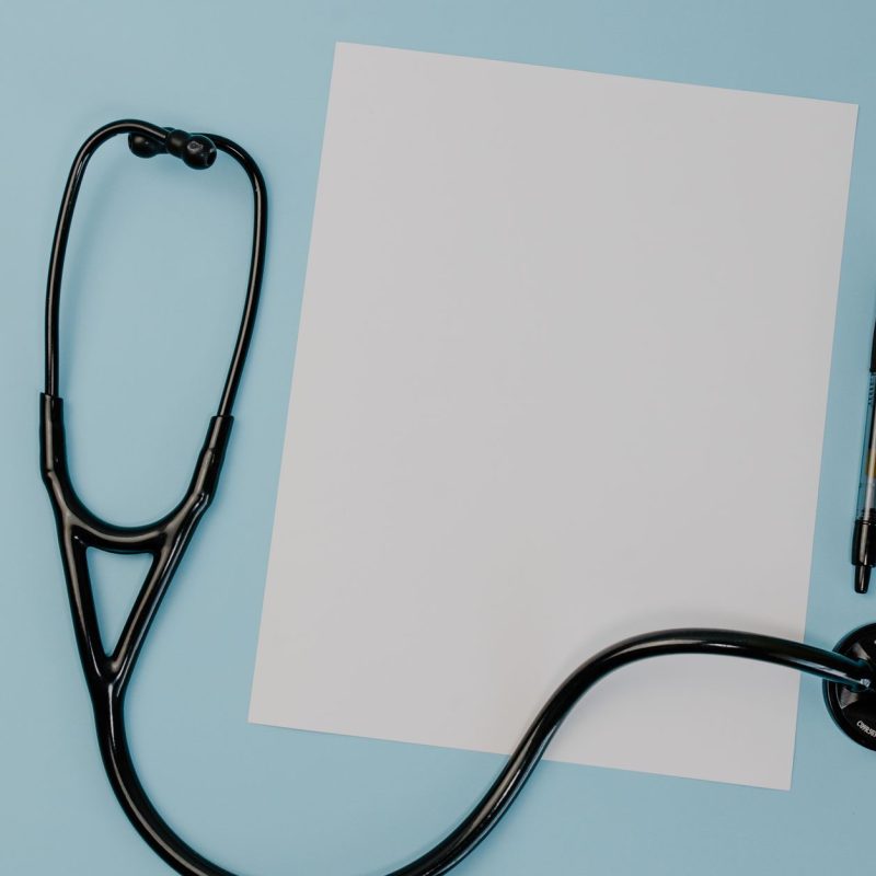 Flat lay of a stethoscope, blank paper, and pen on a blue background. — Why You Actually ought to Use Follinex To Stop Thinni
